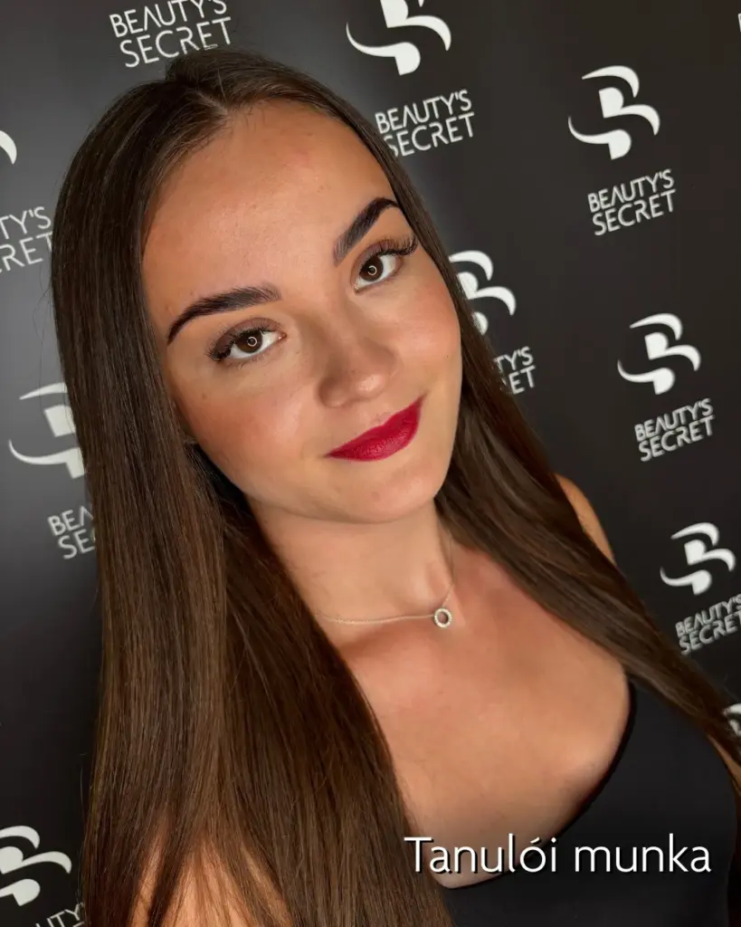 Tanulói munka: női modell formázott szemöldökkel és hangsúlyos szempillákkal a Beauty’s Secret háttere előtt.