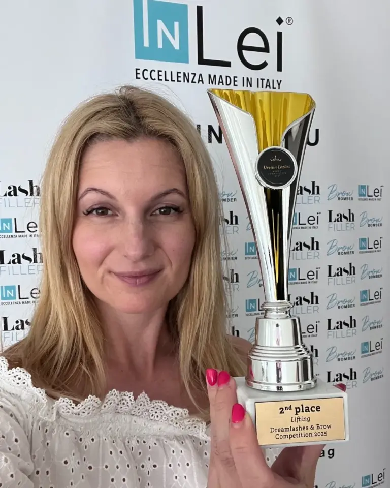 Egy szőke nő a 2025-ös Dreamlashes & Brow Competition lifting kategóriájának második helyezettjeként kupát tart.